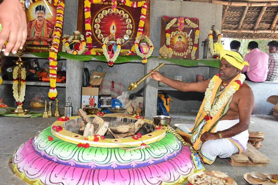 Priest offering ghee into a beautifully decorated homa kund