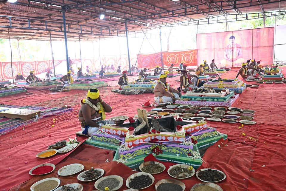 Priests seated before a star-shaped homa kund surrounded by grain offerings