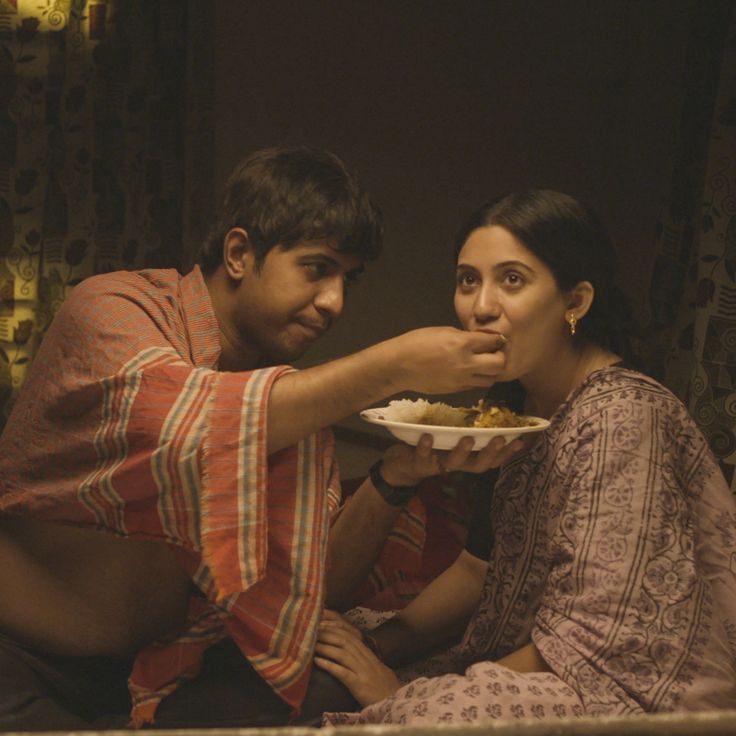 Brother feeding his sister a meal, representing sibling love and family bonds